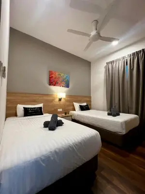 a bedroom with two beds and a ceiling fan at Sunway Onsen Ipoh by EUcation Home in Tambun