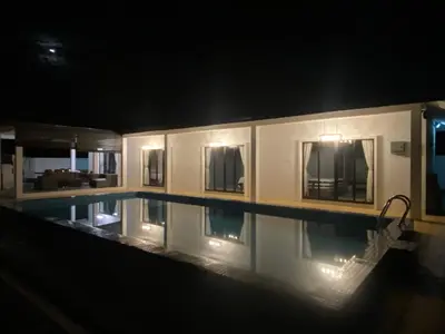 a swimming pool at night with the lights on at Untung5tay in Gua Sai