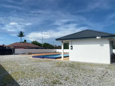 a house with a white garage and a swimming pool at Untung5tay in Gua Sai