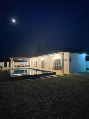 a building with a swimming pool at night at Untung5tay in Gua Sai