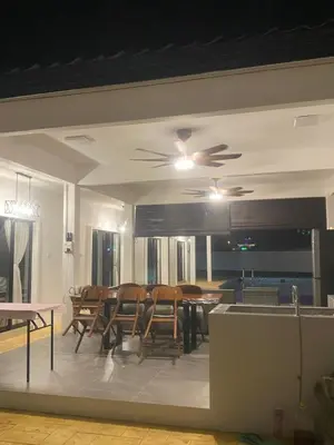 a dining room with chairs and a ceiling fan at Untung5tay in Gua Sai