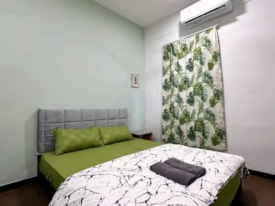 a bedroom with a bed with a green and white blanket at Modern Casual Style Haus 4Room`````Alma in Bukit Mertajam