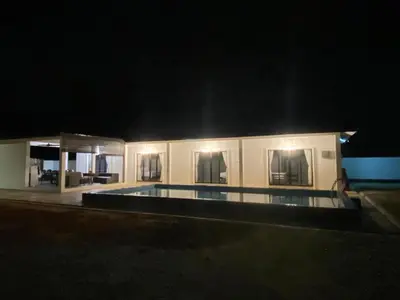 a building with a swimming pool at night at Untung5tay in Gua Sai