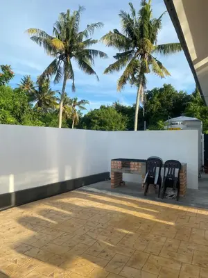 two chairs on a patio with palm trees in the background at Untung5tay in Gua Sai