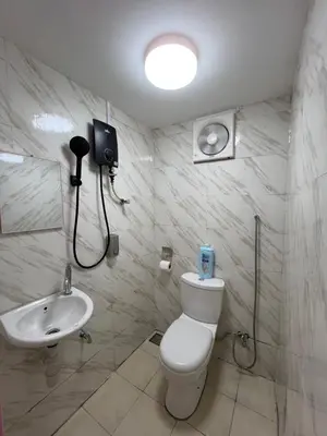 a bathroom with a white toilet and a sink at Comfortable Stay in Ayer Itam