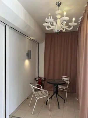 a dining room with a table and chairs and a chandelier at Comfortable Stay in Ayer Itam