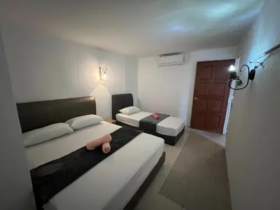 a small room with two beds and a couch at Comfortable Stay in Ayer Itam