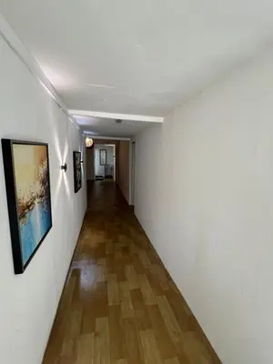 a long hallway with white walls and a wooden floor at Comfortable Stay in Ayer Itam