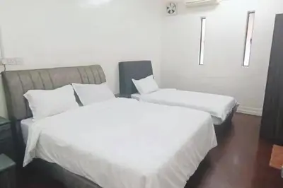 two beds in a hotel room with white sheets at Y.s.a Homestay(100mbps Wifi) in Ipoh