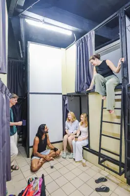 a group of people sitting on a bunk bed at KITA Hostel in George Town