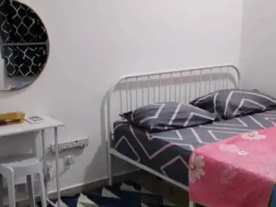a bedroom with a bed and a table and a mirror at MiAmorHomestay in Gua Sai