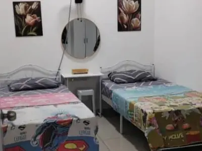 a bedroom with two beds and a mirror at MiAmorHomestay in Gua Sai