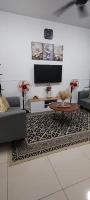 a living room with a couch and a tv at MiAmorHomestay in Gua Sai