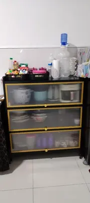 a kitchen shelf with dishes on top of it at MiAmorHomestay in Gua Sai