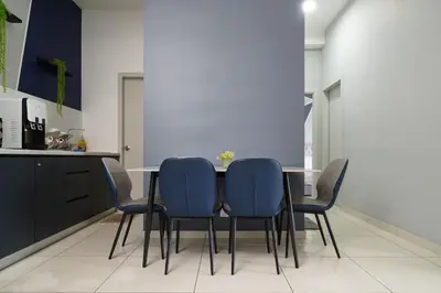 a dining room with a table and blue chairs at L13 Cozy Corner The Horizon Ipoh in Ipoh