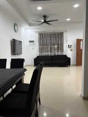 a living room with a couch and a ceiling fan at Bidor Homestay in Bidur