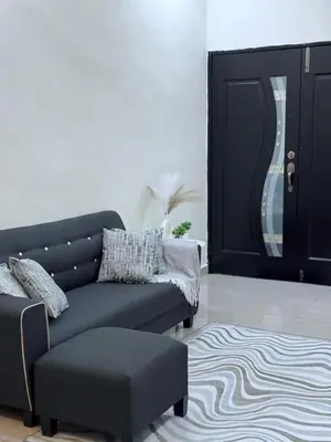 a living room with a couch and a ottoman at Luna De Haus Homestay in Sungai Petani
