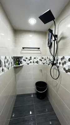 a bathroom with a shower with a black bucket at Luna De Haus Homestay in Sungai Petani