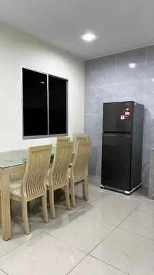 a kitchen with a table and four chairs and a refrigerator at Luna De Haus Homestay in Sungai Petani