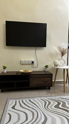 a living room with a flat screen tv on a wall at Luna De Haus Homestay in Sungai Petani