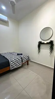 a room with a bed and a mirror on a wall at Luna De Haus Homestay in Sungai Petani