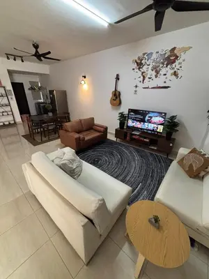 a living room with a couch and a tv at berTIGA Homestay Bertam in Kepala Batas
