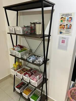 a black shelf with food on it next to a wall at berTIGA Homestay Bertam in Kepala Batas