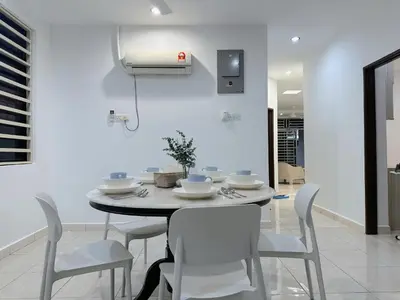 a dining room with a table and white chairs at 10Pax BM\u5927\u5c71\u811a Alma Single storey Semi-D 5-minute To Aeon Mall in Bukit Mertajam