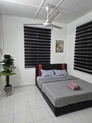 a bedroom with a bed and a ceiling fan at Syaf Homestay in Lunas