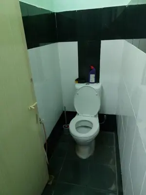 a bathroom with a white toilet in a stall at Syaf Homestay in Lunas