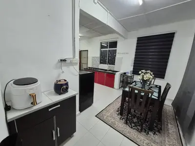a kitchen with a small table and a counter top at Syaf Homestay in Lunas
