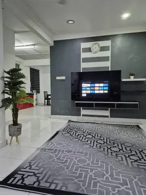 a living room with a television and a rug at Syaf Homestay in Lunas