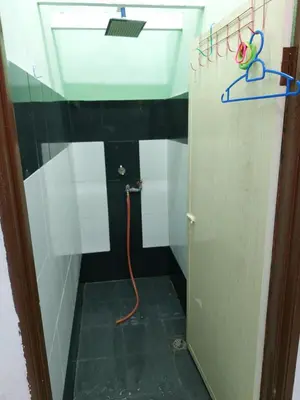 a small bathroom with a sink and a hose at Syaf Homestay in Lunas