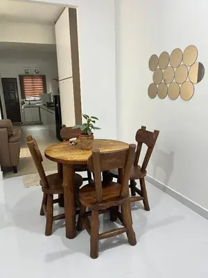 a wooden table and chairs in a living room at Saujana Number 5 in Gua Sai