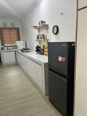 a kitchen with a black refrigerator and a counter at Saujana Number 5 in Gua Sai