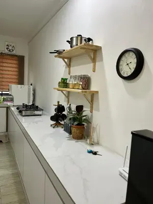 a kitchen with a counter with a clock on the wall at Saujana Number 5 in Gua Sai