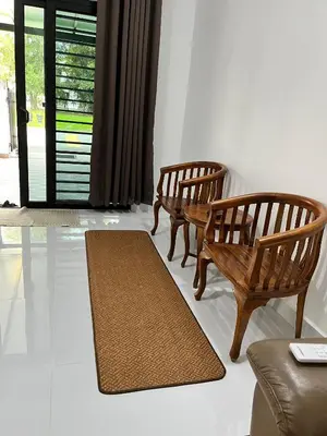 two wooden chairs and a rug in a living room at Saujana Number 5 in Gua Sai