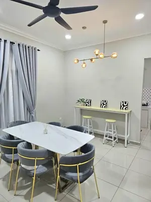 a dining room with a white table and blue chairs at Adam Homestay in Gua Sai