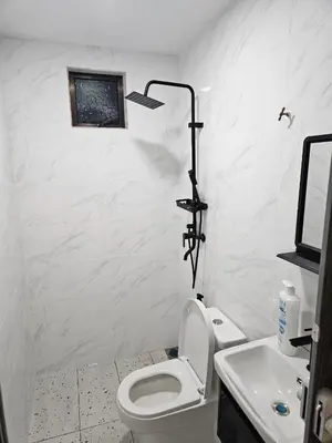 a white bathroom with a toilet and a sink at Adam Homestay in Gua Sai