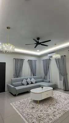 a living room with a couch and a ceiling fan at Adam Homestay in Gua Sai