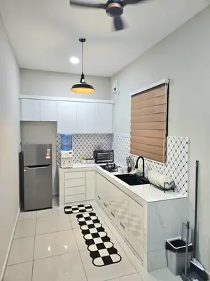 a white kitchen with a sink and a refrigerator at Adam Homestay in Gua Sai