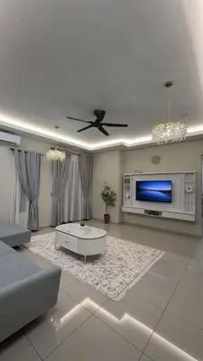 a living room with a ceiling fan and a tv at Adam Homestay in Gua Sai