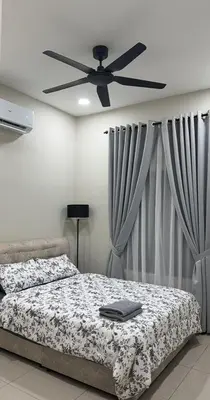 a bedroom with a bed and a ceiling fan at Adam Homestay in Gua Sai