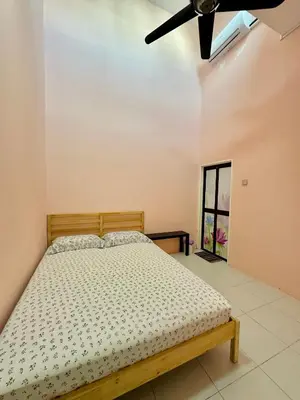 a bedroom with a bed and a ceiling fan at Ahnaf Guesthouse in Sitiawan