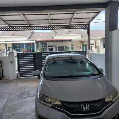 a car parked in a garage in front of a house at Alisa Homestay in Lunas