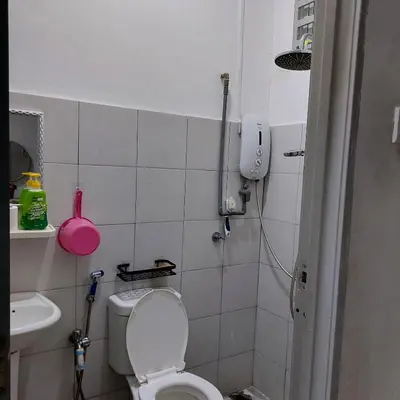a small bathroom with a toilet and a sink at Alisa Homestay in Lunas
