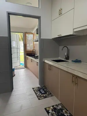 a kitchen with white cabinets and a tile floor at Casa De Olive Islamic Only in Kampong Batu Lapan