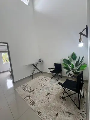 a living room with two chairs and a potted plant at Casa De Olive Islamic Only in Kampong Batu Lapan