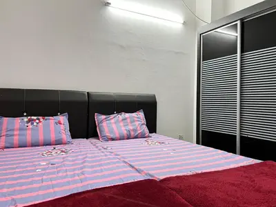 a bedroom with a large bed with pink and blue stripes at Dlaili Homestay in Tanjung Karang