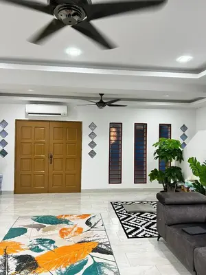 a living room with a ceiling fan and a brown door at Dlaili Homestay in Tanjung Karang